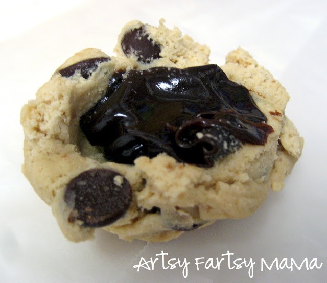 Place cookie dough in fridge or freezer for a couple hours, then form the dough into 1 inch balls and set aside. Either flatten or make a bowl out of a dough ball, then scoop some of the fudge into the center of the 'bowl' and then enclose the fudge in the center of the dough ball.