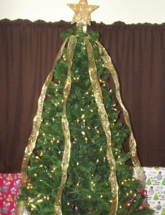 After cutting the ribbon into individual lengths, gather them and make sure that any patterns or designs are all going in the same direction. Once you have them in order, secure them tightly using a rubber brand, bread tie, or other method to keep them held together tightly. drape them over the tree