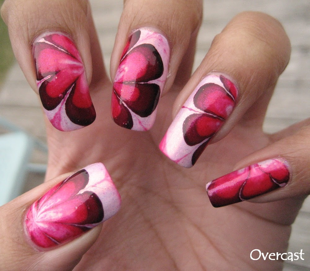 This flower nail design looks so realistic, but they're easily created using the marble nails technique by combining a few drops of thick nail polish and water and making your own design, unique every time, by swirling the nail polish with a toothpick. Absolutely love these!