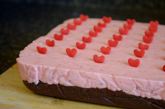 Stir a few minutes while the red hots melt and turn your fudge a pretty pink. Pour on top of the chocolate oreo fudge and let set on the counter for 10 minutes. Top with sprinkles and place in the fridge to set up completely.