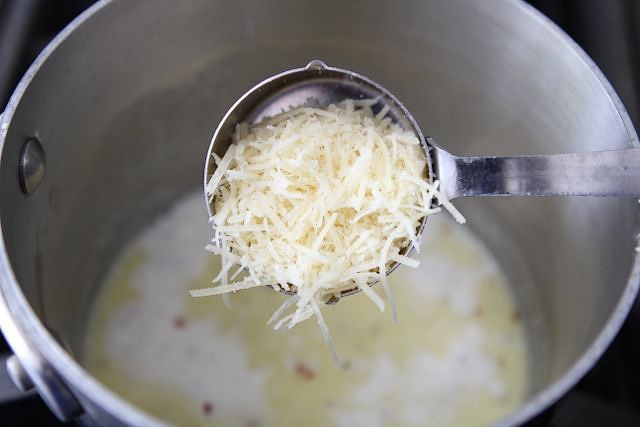 Add in the salt, pepper, and chili flakes, and Parmesan cheese. Continue stirring. The sauce will thicken pretty quick, so make sure you keep stirring.