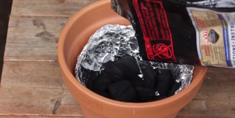4. Pour charcoal inside, filling the pot up to about two inches from the bottom.