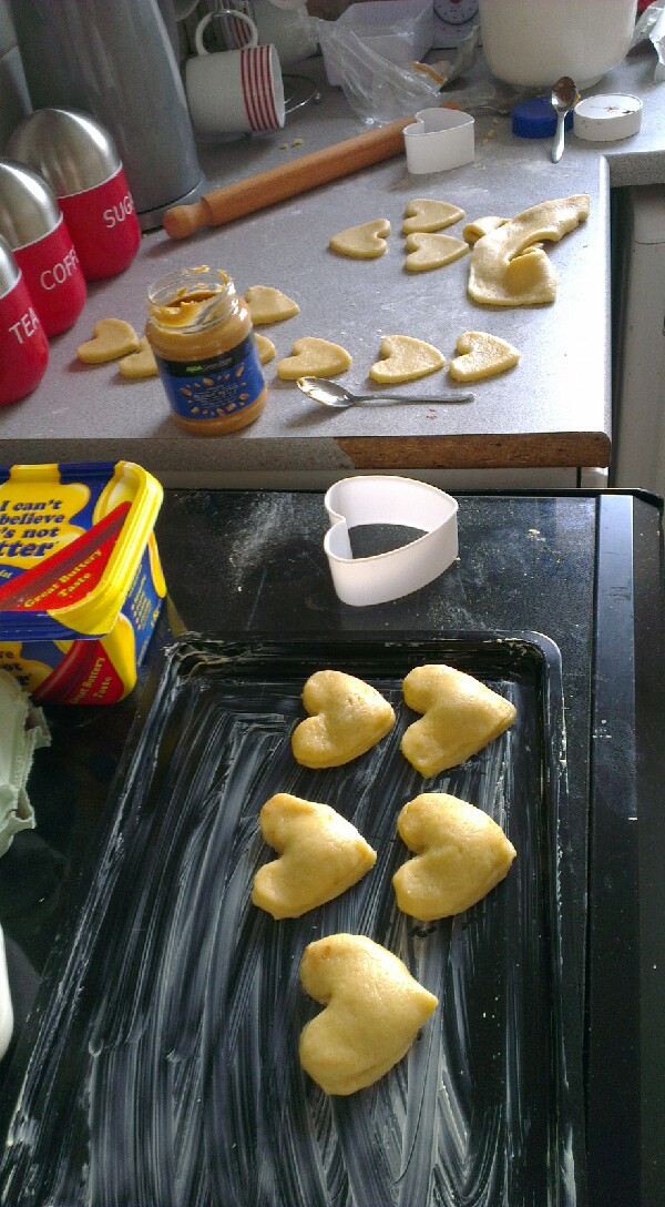 cut your hearts, or shapes out. ensure you have an even number of bottoms and lids. then place a very small amount of your middle ingredient in the middle of a shape and put a second shape (the lid) on top.