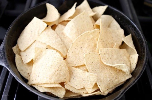 Step 7: Preheat the oven to 400ยบF and start building your nachos in an oven-proof dish. First, add the tortilla chips.