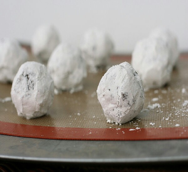 Step 4: Line cookie sheets with parchment paper. Roll dough into one inch balls and coat each ball with confectioner's sugar. Press a Hershey's kiss into each ball before placing onto prepared cookie sheets.