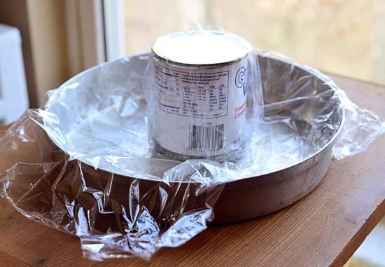 Line a round cake pan with plastic wrap, and give it a light coat of cooking spray.  Cover the empty  milk can with plastic wrap and place in center of cake pan.