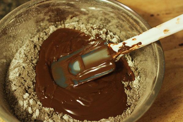 Pour melted chocolate into the mixing bowl containing the dry ingredients and stir until combined. Mixture will be very thick, similar to brownie batter. Spoon mixture into a piping bag (no coupler or tip is needed) or into a sandwich bag with the corner sliced off.