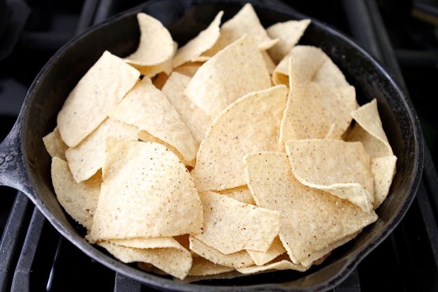 Preheat the oven to 400ยบF and start building your nachos in an oven-proof dish. First, add the tortilla chips.