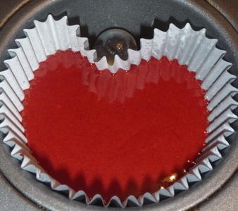 Mix up your red velvet recipe then Take a marble and put it in the cupcake tray like the cupcake as shown above to get a neat heart shape if you'd like for extra valentine spirt.