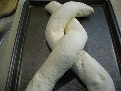 Place loaves, seam sides down, in an "X" pattern on baking sheet or stone.  Crisscross ends of dough to form a large figure "8" keeping leaving two 1-1/2-inch openings in center of twist.
