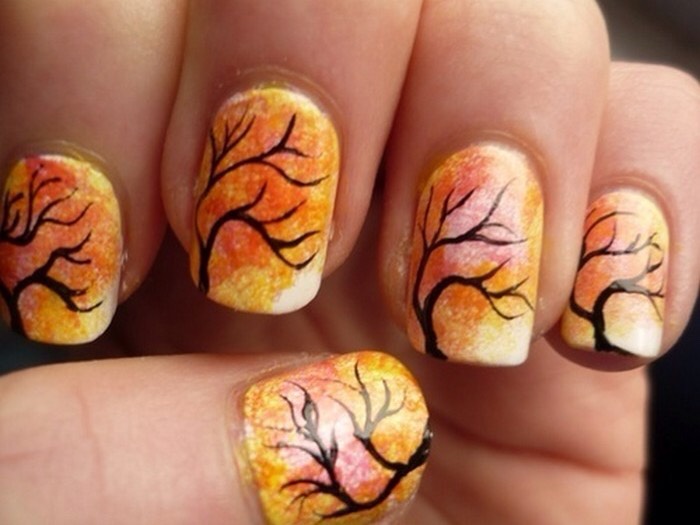 Take a sponge and dab it in orange and yellow nail polish, then stamp it on your nails, for a pretty background. Use a black striper for branches.
