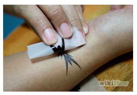 Peal off the edge to see if your tattoo is sticking yet. If not keep holding warm cloth to it till it does