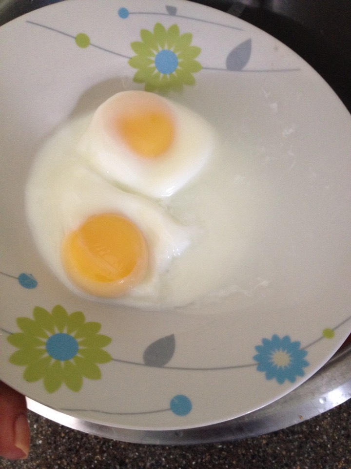 The whites will be formed around the yolks (the yolks may look runny but they are not). Next you want to tip the bowl and drain the water. The eggs should be slightly adhered to the bowl so you shouldn't need to hold them in place. The eggs stay formed together so all that drains is the water.