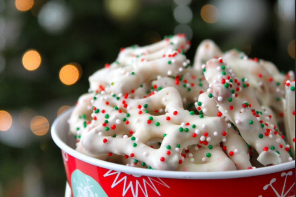 Melt white chocolate in the top of a double boiler, stirring constantly. Dip pretzel 1/2 way into white chocolate, completely covering 1/2 of the pretzel. Roll in toppings & lay on wax paper. Continue this process until all the chocolate is finished. Put in refrigerator for 15 minutes to harden!