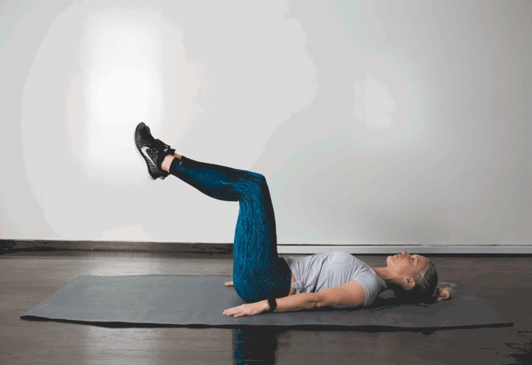 1. Heel Tap 

Lie faceup, hands under your butt, knees bent, feet lifted into table top position. Slowly lower your flexed feet forward until your heels barely touch the ground. Squeeze your abdominals to help raise your feet back up to table top.