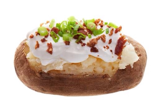 6. Fully Loaded Baked Potatoes
This popular side dish is packed with extra calories and fat. Potatoes themselves are high in calories, as they are a starchy carbohydrate. Topping them with butter, sour cream, cheese, bacon, and more can be heart attack inducing. 