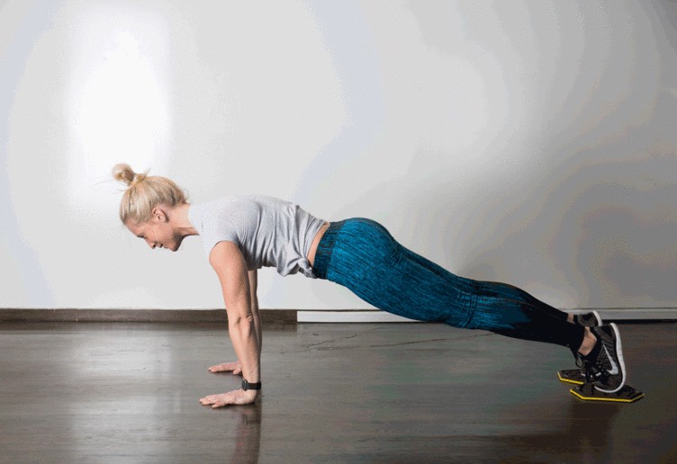 4. Slider Pike 

You'll need sliders or towels to pull off this move.
Start in high plank position with both feet on sliders. Squeeze low abs and pull feet toward your hands, lifting your hips toward the ceiling into a pike position. Slowly push feet out to lower into starting position.
Make it easier: Perform sliding mountain climbers, moving one leg forward at a time.