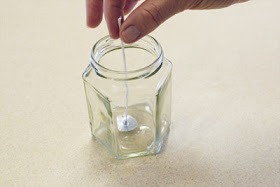 Step 2: While this is melting, secure your wick to the bottom of your mason jar. Apply a bit of hot glue to the center of your jar and....