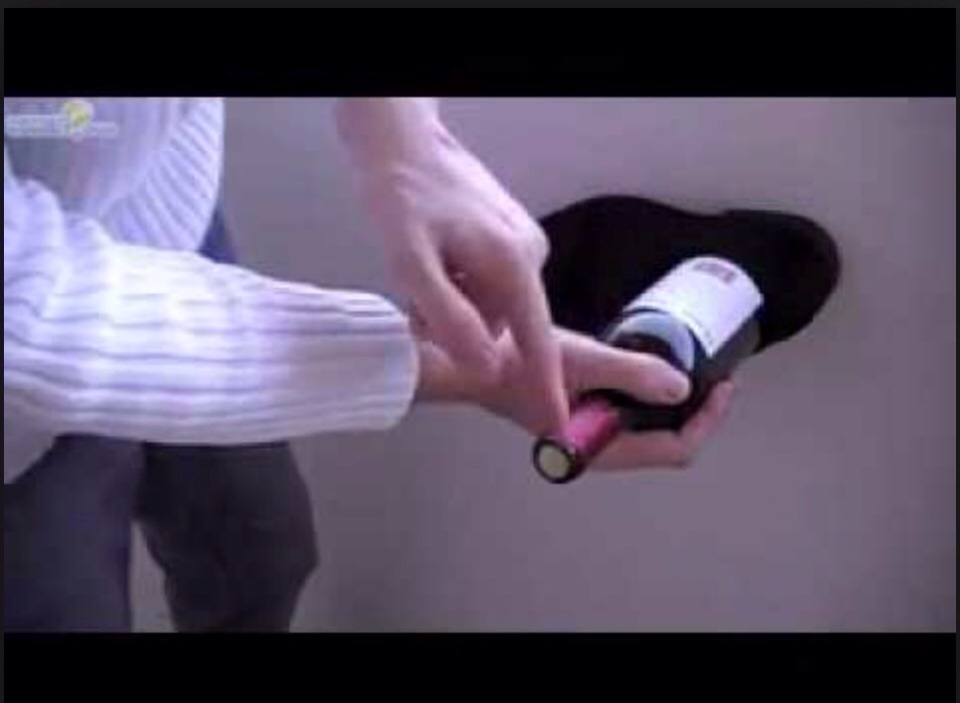 Place the bottle in a shoe and gently bang it on the wall until the cork starts to work it's way out.     