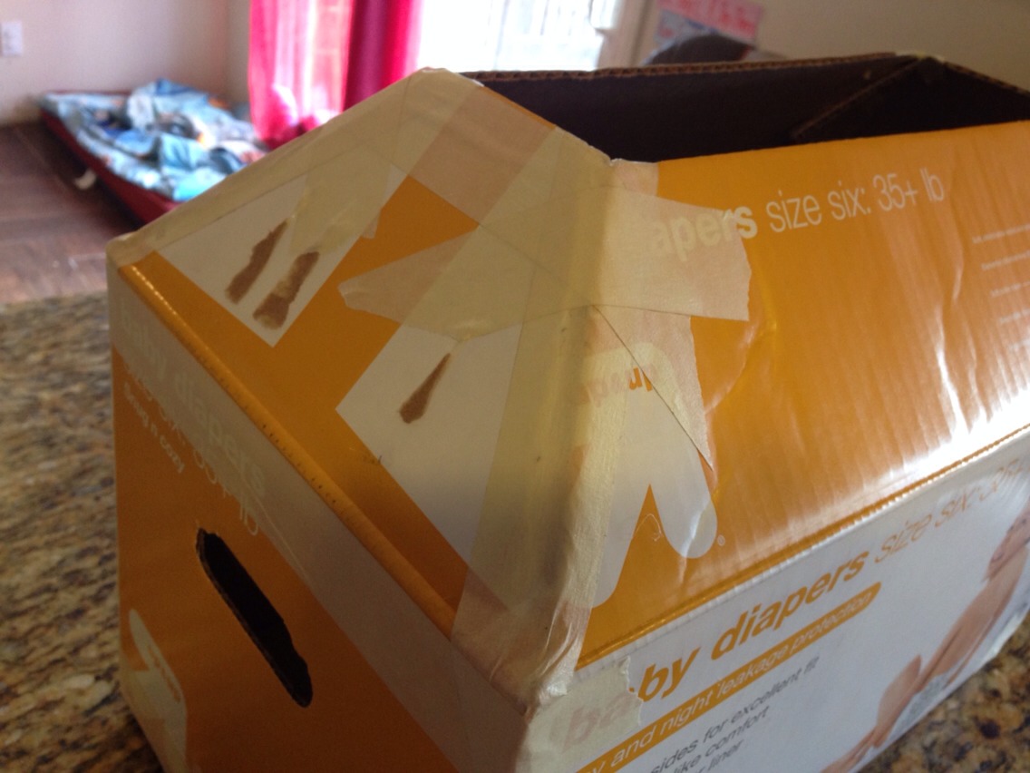 Use glue stick to wrap the sides and bottom of the box only in packing paper. Leave the holes on the side open. With flaps attached.