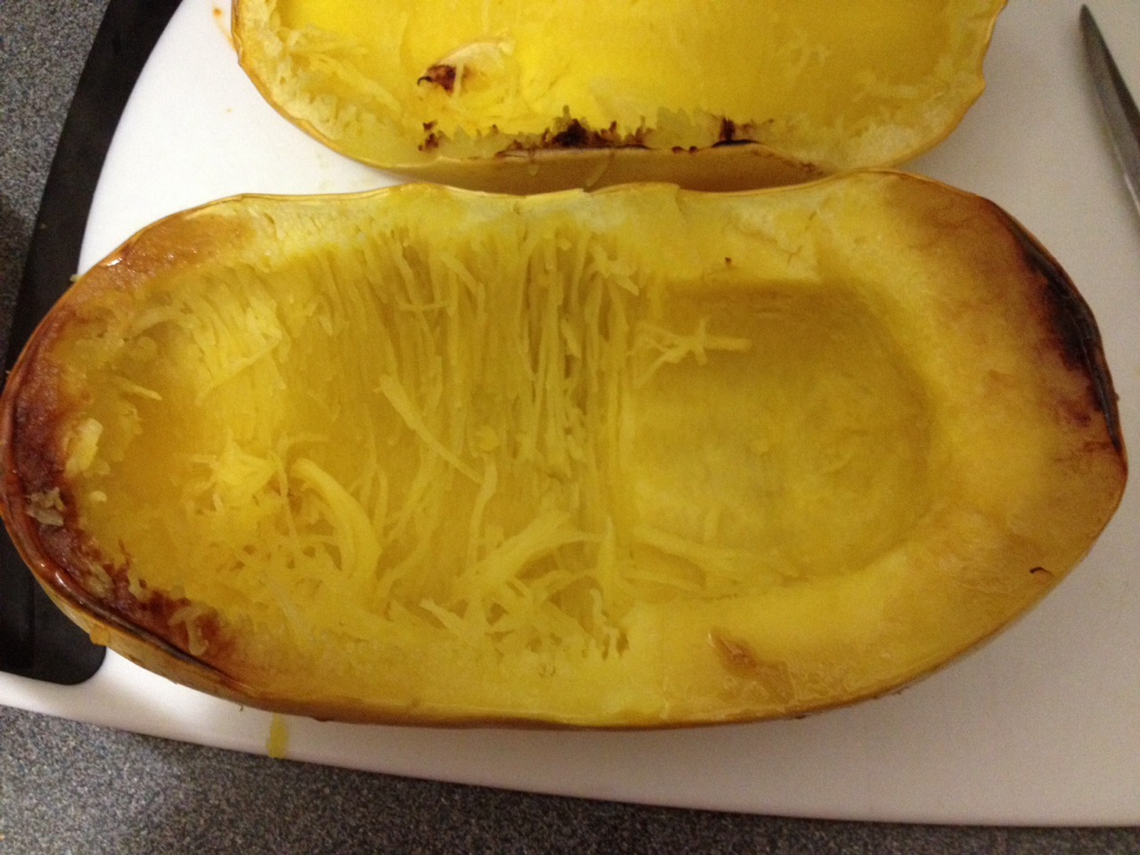 Scoop out squash with a large spoon. The cooked squash naturally shreds into small strips like spaghetti noodles (no need to cut). Put portions onto plate and cover with sauce.
