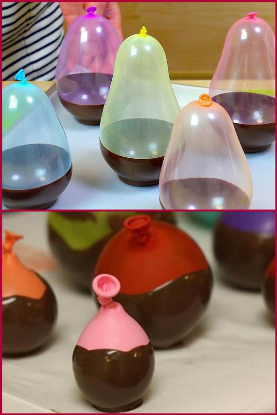 take the water balloons and cover the bottom half of the balloon with chocolate
