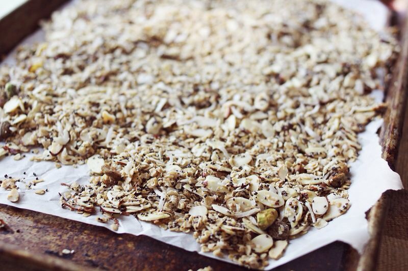 In a pot over medium heat stir together the butter, sugar, honey and vanilla extract until the butter melts. Bring to a boil then remove from the heat. In a bowl combine the granola and butter mixture so that all the granola gets coated. Line an 8x8 square pan with parchment paper.