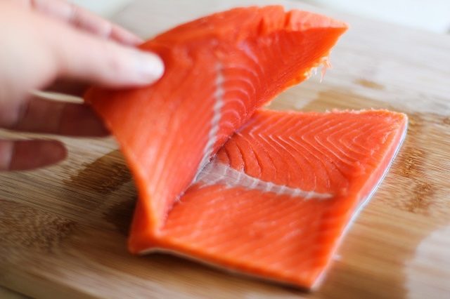 Tip

It's OK if you cut all the way through the salmon fillet. You can still stuff it by placing the slices one on top of the other.

Step 8. Stuff the Salmon

Use a large spoon to distribute the stuffing into the centers of each of the salmon fillets.