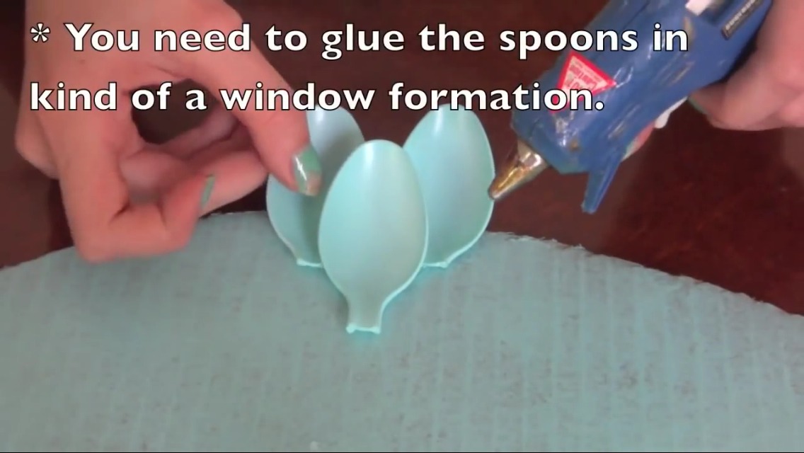 Now you can start hot glueing your painted spoons on to the base. It's best to glue them in a window formation like in the picture. 2 above then one underneath AKA "window formation". Just continue this step all the way around the base.