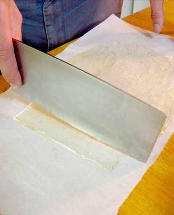 Place the blade of a large knife (not necessarily your best) directly into your burner to heat.  If you have an electric stove, you can use a lighter.  Once the blade is hot, begin to cut your sheets of sugar into strips.  Cut edges to be the length of a real slide. 