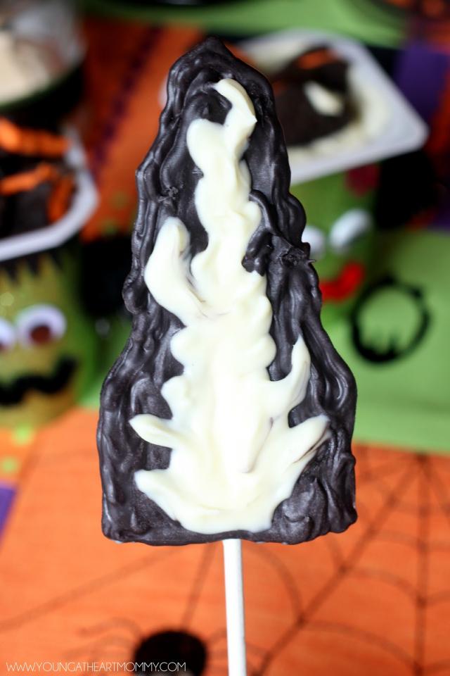 Place the hair pieces in the refrigerator for 10-15 minutes or until hardened. Remove and use a dab of melted chocolate to secure a cake pop stick on the back of each. This will help it stand up in the pudding cup and remain straight.