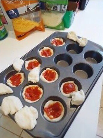 Put about a 1- 1/2 tablespoons of pizza sauce inside each of tins. You can have as much or as little sauce as you like, but once the pizza cupcakes are finished it will seem like there is less sauce from the dough expanding. If you like more sauce I wouldn't do more than 2 tablespoons.