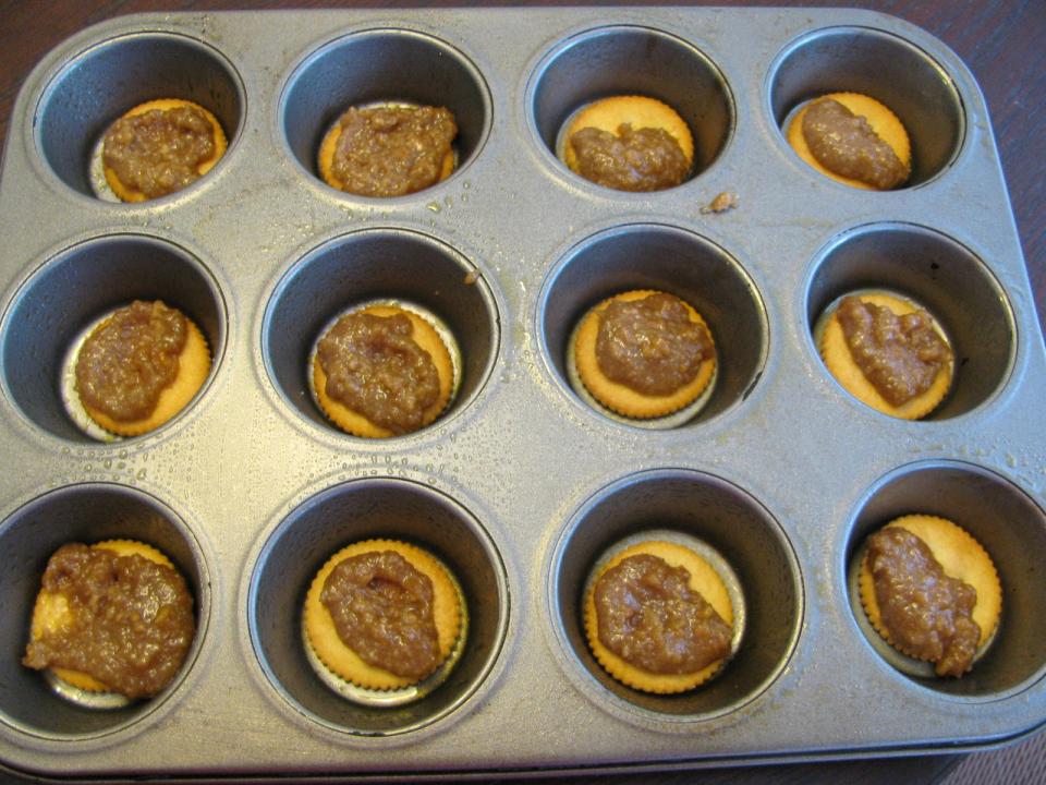  Divide the sugar and graham cracker mixture in half and spread a spoonful on top of each cracker.  Don't worry about getting it exactly spread out,  when you place the next cracker on top it will even it out
