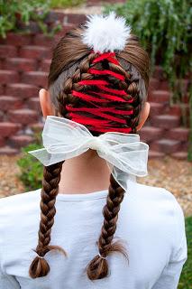 Now grab your red ribbon and your yarn needle.  (You will want to make sure the ribbon is long enough to weave on both sides of your braids.)  Feed your ribbon through your top elastic so that the exact middle of the ribbon is folded at the band.  