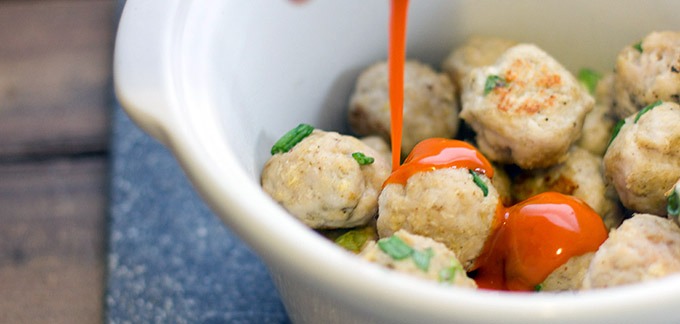 3. Transfer meatballs into a 4-quart slow cooker. Cover with Buffalo sauce. Place lid on slow cooker and cook on low for 2 hours.
