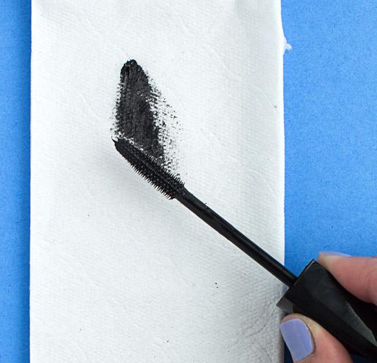 2. Wipe off excess mascara on a tissue to prevent clumps. A brand new bottle of mascara can transfer a lot of extra product on the wand for the first few uses, causing clumpy lashes. So before your first coat, glide the brush over a napkin or tissue to remove any excess formula.