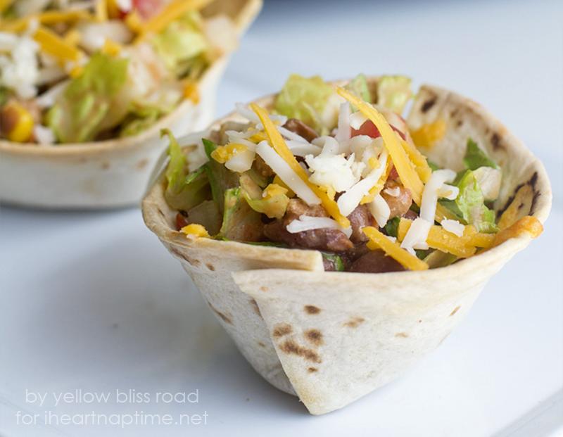 Toss that salad up until it’s evenly mixed, then spoon the mixture into the baked taco cups. Sprinkle with cheese, cilantro or green onions.