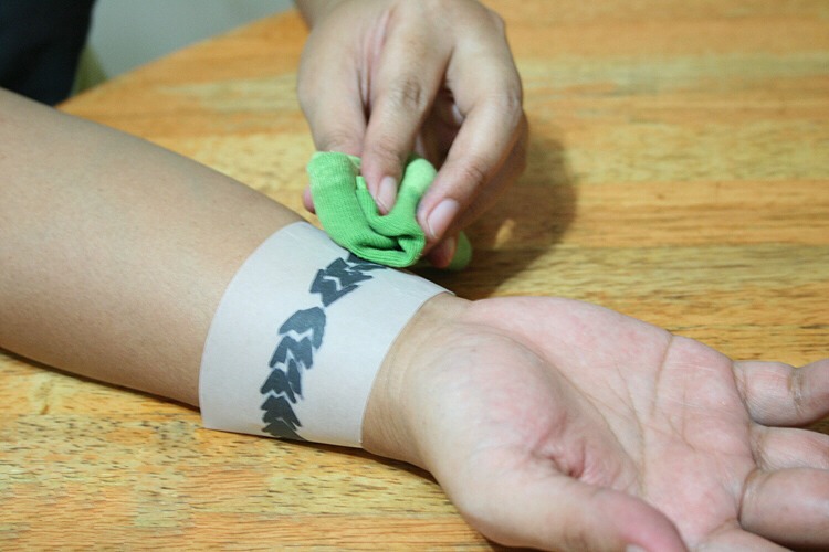 Step 4: Place the paper with your design on it in the exact spot where you want your tattoo to be. Press the wet cloth firmly on the tattoo design for approximately 30 seconds.