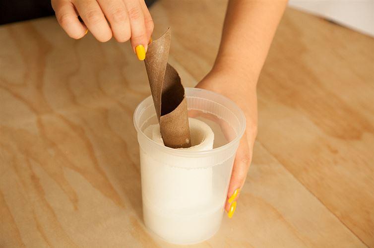 Take the roll and place it in your container. Pour on top the mixture you made in the bowl.

Place the lid on top. Turn the container upside down, let it soak for five minutes. Remove the lid, and then remove the cardboard core.