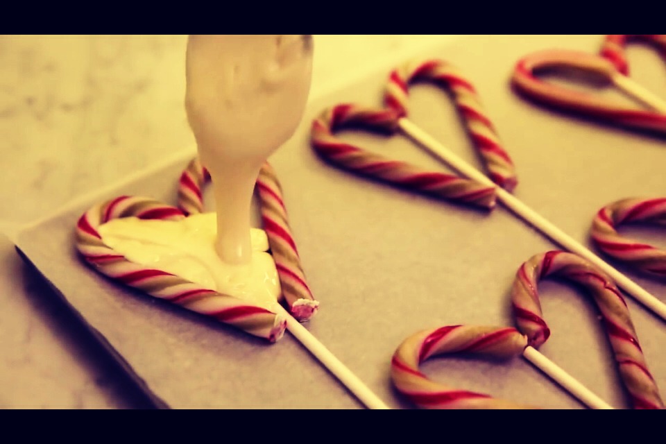 Remove the chocolate from melting and if baking chocolate was used immediately place the chocolate in the center of the candy canes until full. If regular chocolate was used wait a couple of minutes until the chocolate isn't so runny then place the chocolate on the pop.