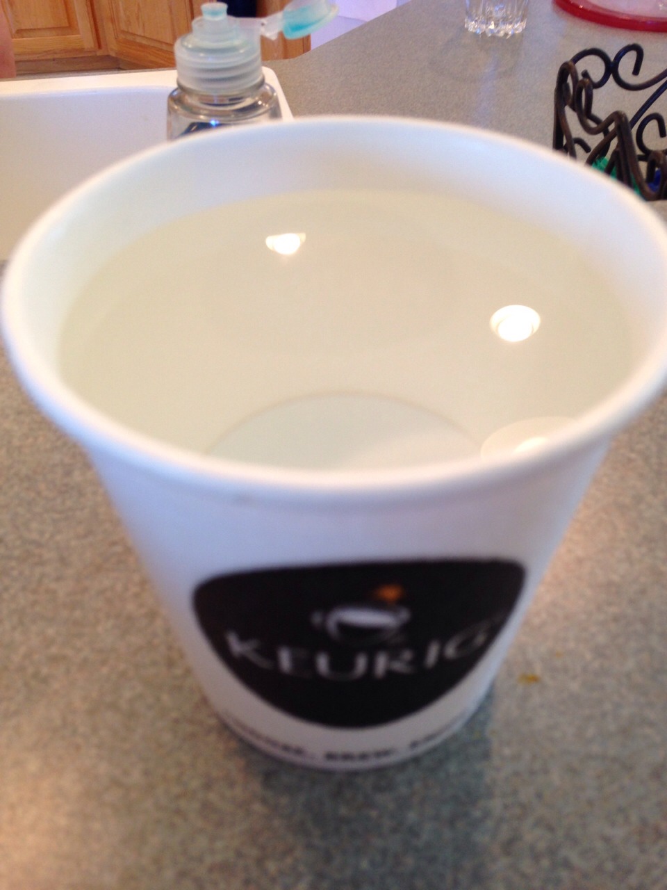 Fill the cup with the bottled water about 1 cm below the rim