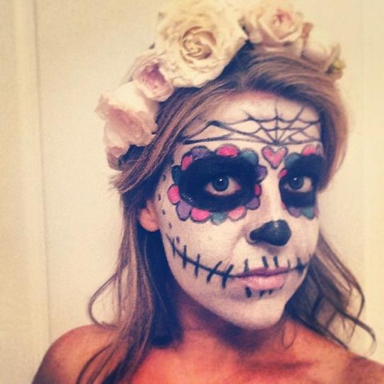 4.    Draw everyone’s attention to your eyes by applying black shadow around them and draw flower petals in various bright tones over your shadow. Paint skeleton-resembling lines and stretch them from your lips to your ears.