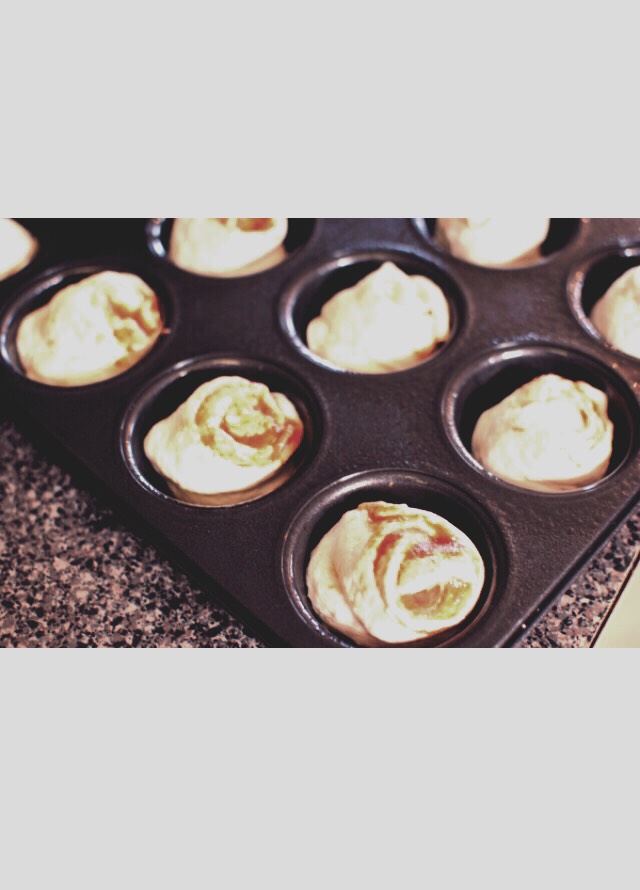 into a greased muffin pan with the swirled part facing up.
You’ll top with a little more mini pepperonis and some shredded cheese before baking. Then bake them up and you’re done!