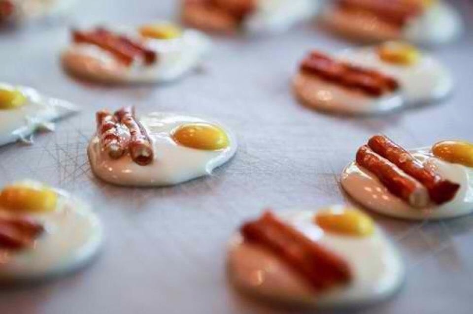 Melted white chocolate for the yoke. A yellow m&m for the yoke (face the m down) and add pretzel sticks for the bacon.