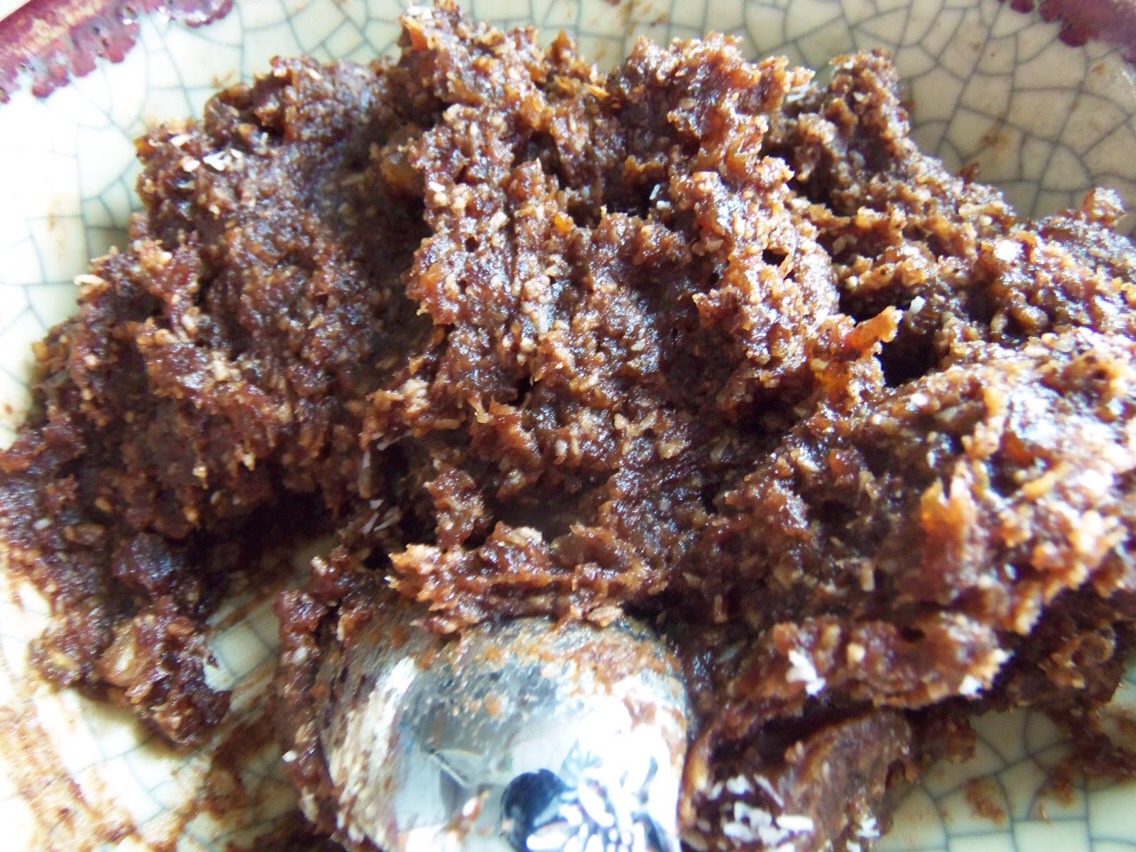 Now taking your condensed milk, using the whole tin, pour it into your crushed biscuit mixture. Then mix it through until spread evenly throughout, it will be sticky and quite tough to mix and should look something like this!