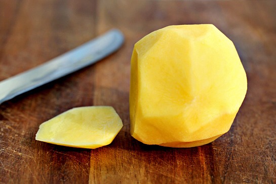 3. Then, using a sharp knife, slice a 1/4-inch piece off the potato lengthwise in order to create a stable base for you to work with.