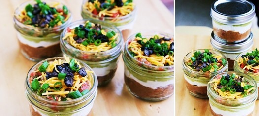 1 2.25 oz can black olives, chopped or sliced
½ cup green onions, chopped

Instructions
In a small bowl mix the refried beans & taco seasonings.
Spread the mixture in a pie plate sized platter or several small individual containers.
Next, layer the sour cream followed by the guacamole & salsa