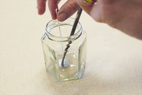Step 3: Arrange your wick such that it stands upright. I then put a dab of hot glue on the bottom of my mason jar and glued it down by applying pressure with the end of a paintbrush. This is only one of several ways to balance your wick. There are no rules!