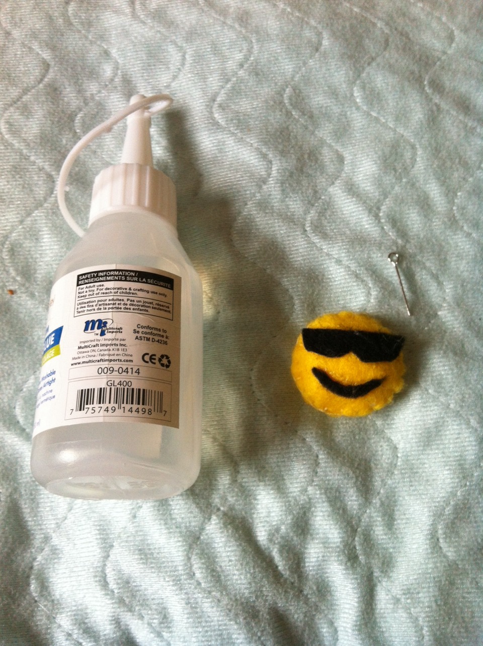 Once you've sewn your emoji together, you can attach a safety pin at the lack and wear it like a pin :) but im going to turn this to a cellphone accessory. Take an eye pin and put put glue around it, then insert it in the emoji 