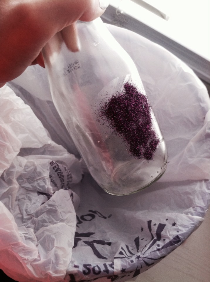 Step 4: Poor glitter on one side of the bottle where the sticky part is. Make sure to have a garbage pail under your bottle!